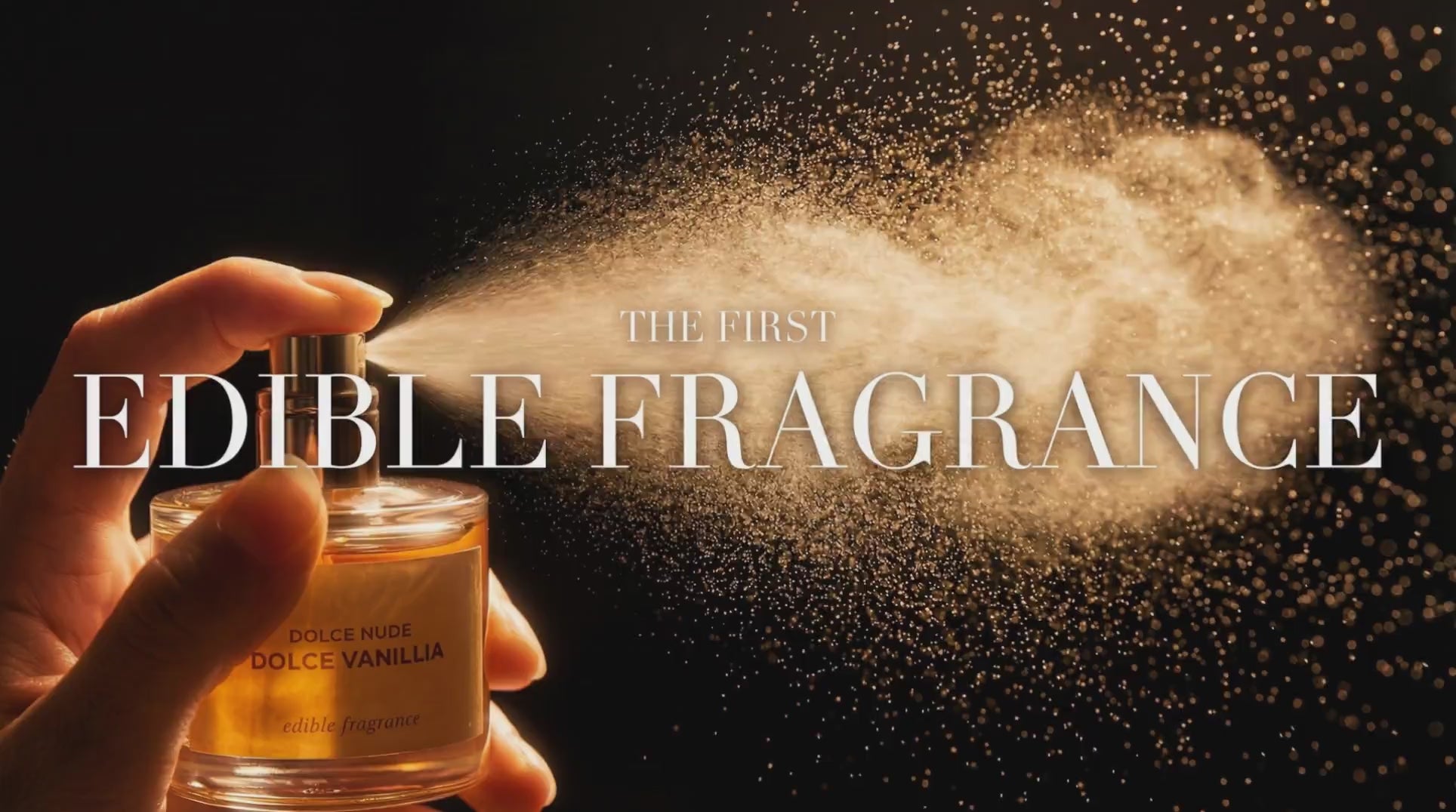 Load video: DOLCE NUDE Vanillia Dolce edible fragrance bottle held in hand with golden sparkle particles floating on dark background, text reads the first edible fragrance